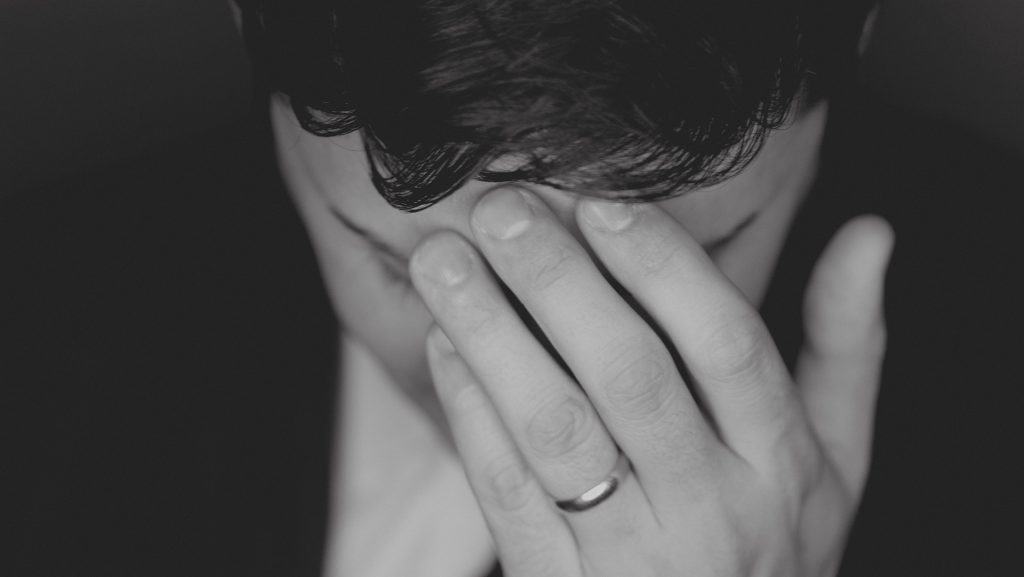 Man holding his head in deep thought. The word of God calls us to "take every thought captive" when fighting porn addiction. We should capture our thoughts before they become sexual. Here's how addiction to porn destroys sexual health