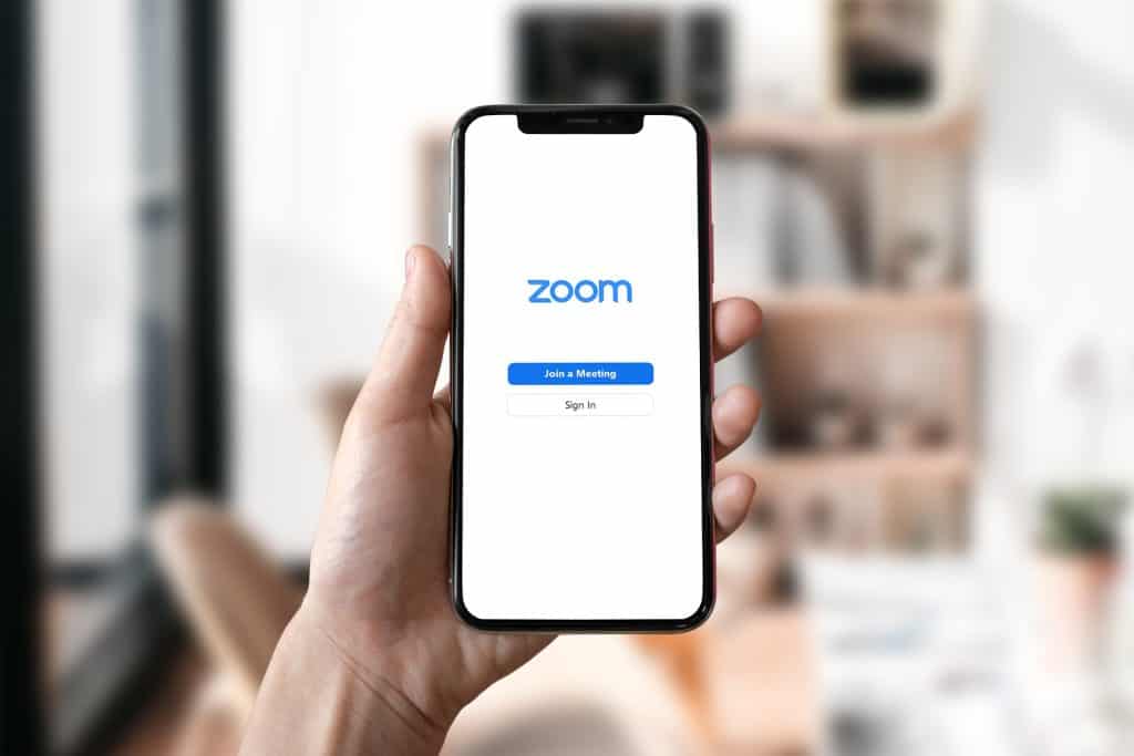 Hand holding  phone  setting up Zoom credentials. We use Zoom to hold meetings with porn addiction online accountability partners